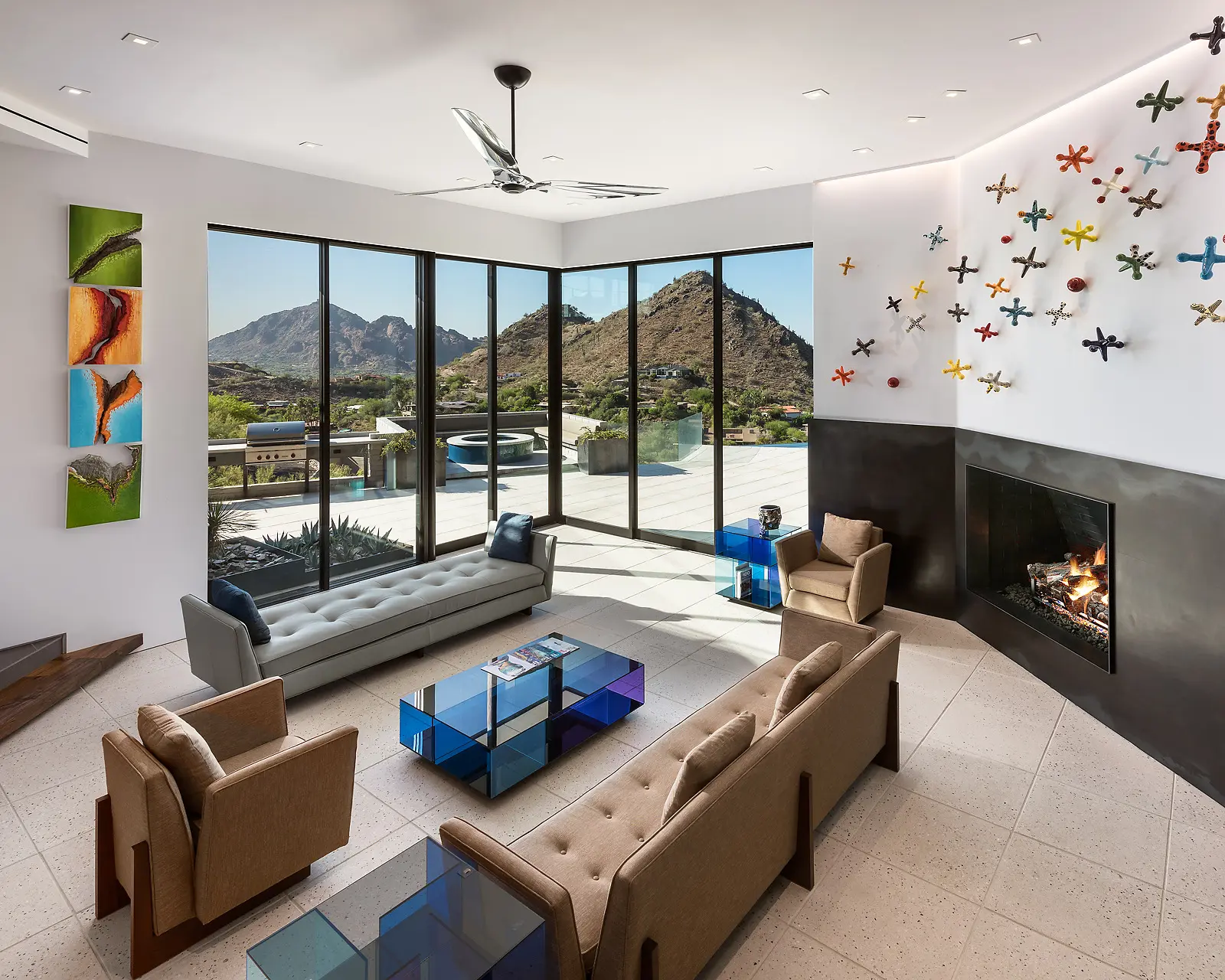 Modern living room with large windows and mountain views.
