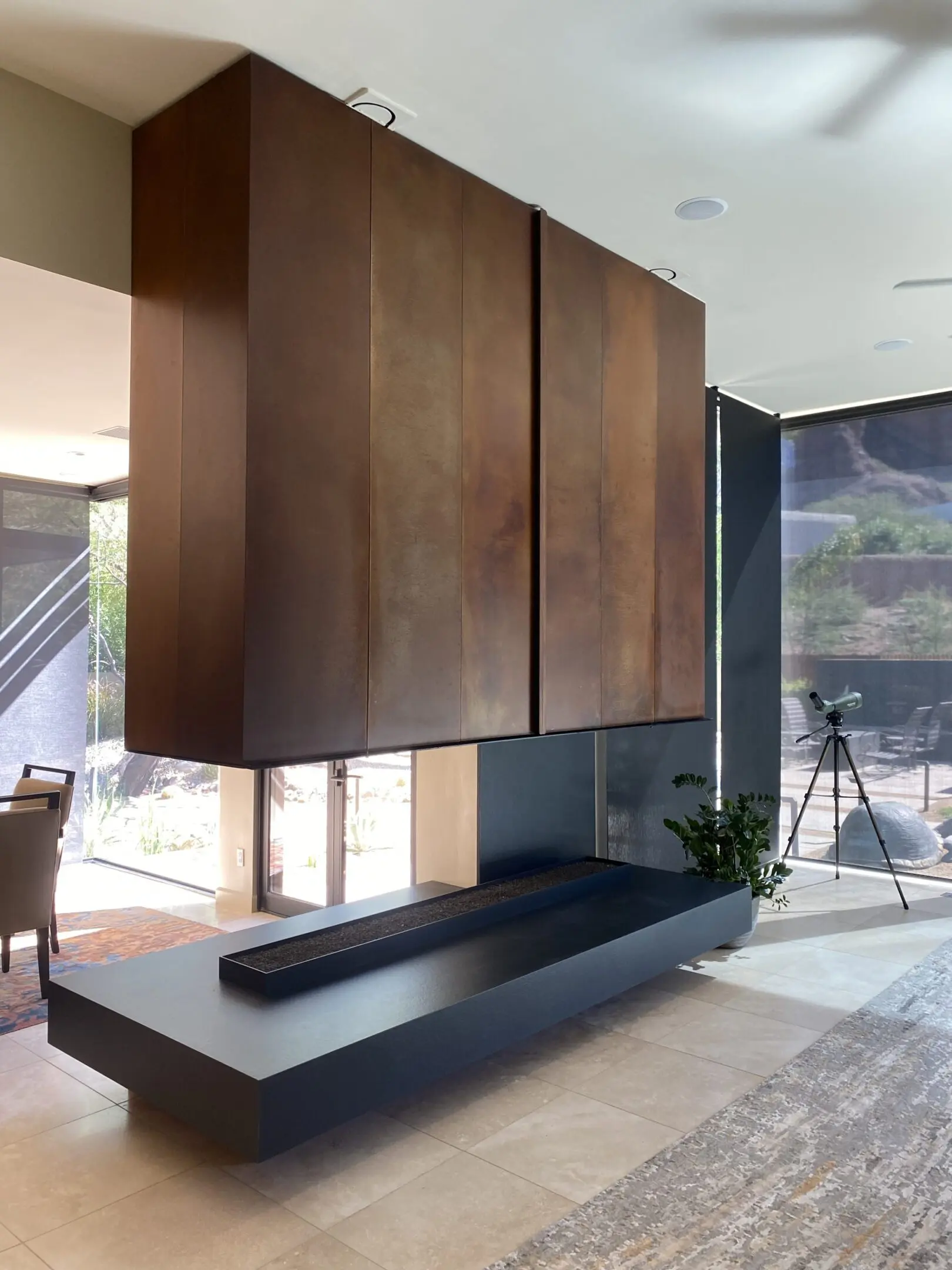 Modern brown wood cabinets suspended above a sleek black bench in a contemporary living space.