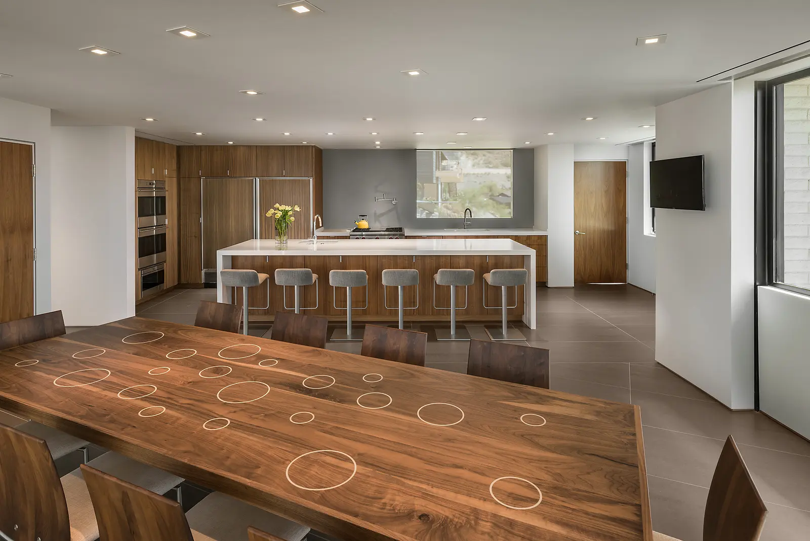 Modern kitchen with a large island and wooden dining table.