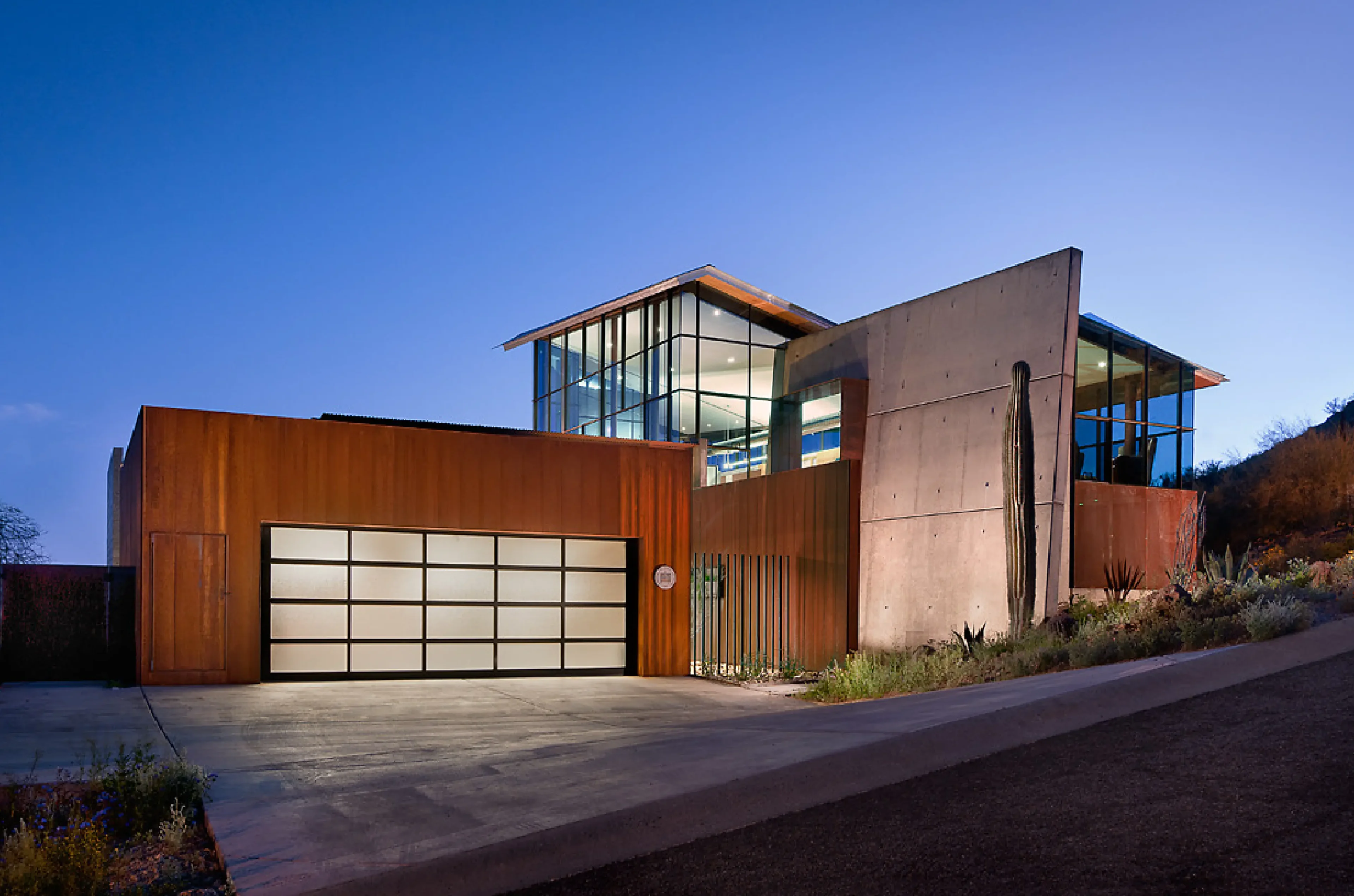 Modern house with glass and concrete design at dusk.