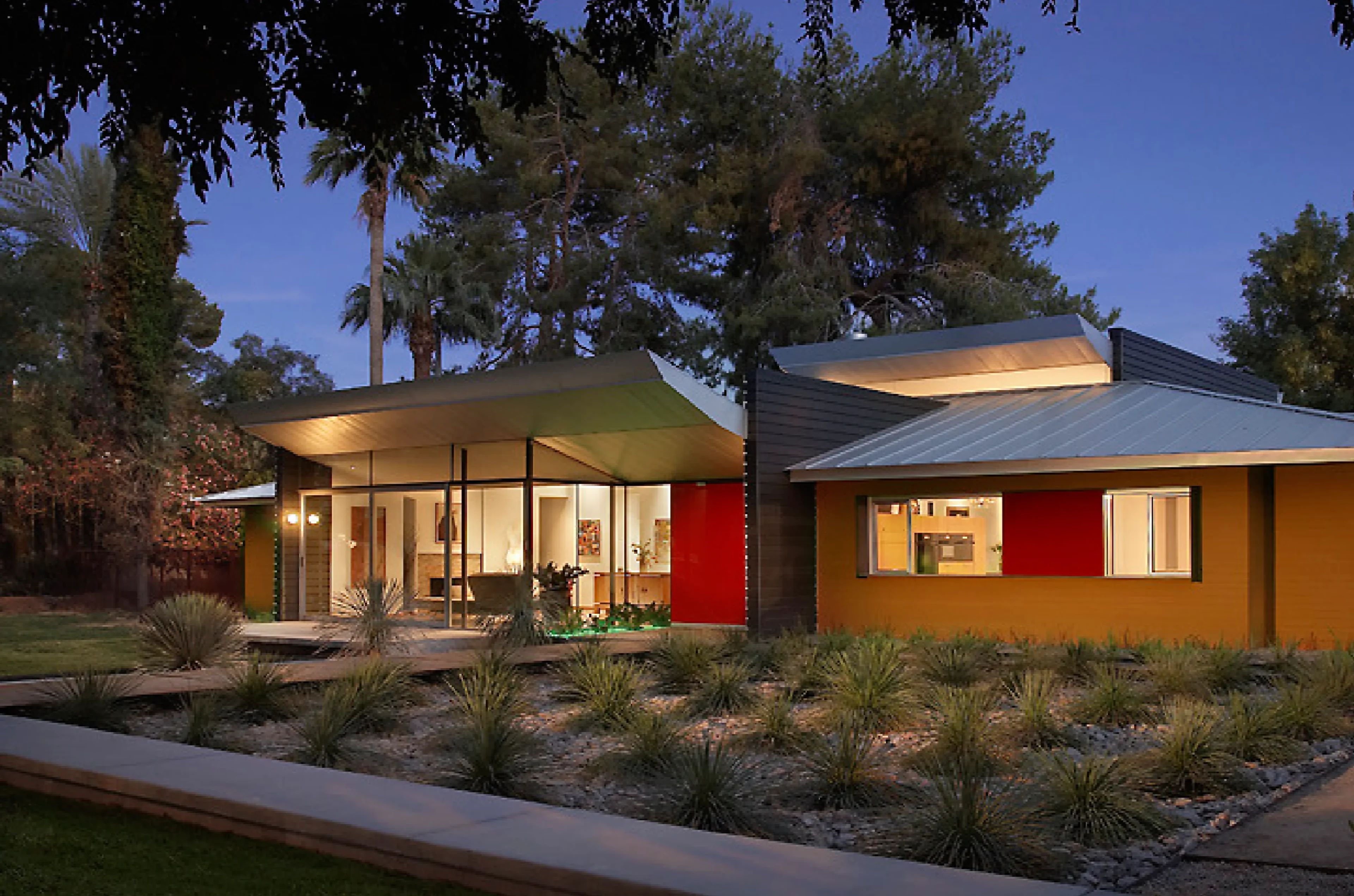 Modern single-story house with large windows and vibrant red accents.