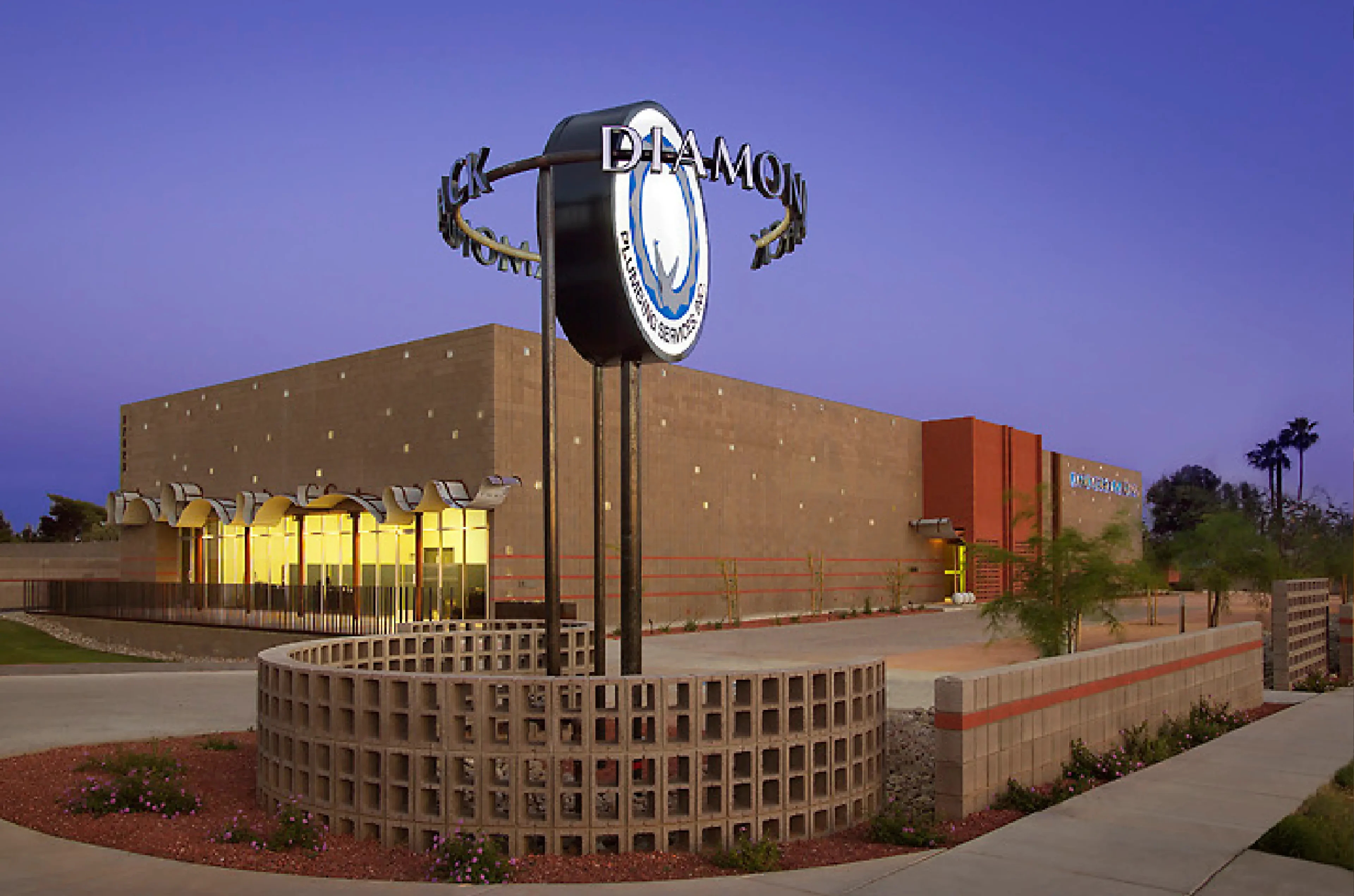 Modern building with a clock tower at sunset.